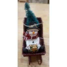 Trineo con figura y árbol nevado